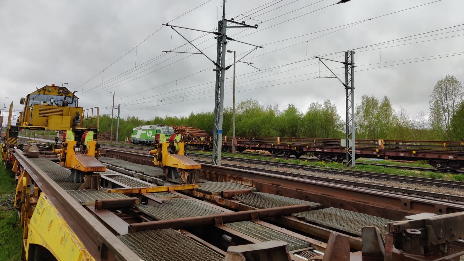 Veturi tuomassa kolmea täyttä kiskovaunustoa Hankasalmelle. Kuvassa etualalla kiskonjakoyksikkö odottaa työskentelyn aloittamista sivuraiteella. Kuvassa näkyy myös kiskonjakokone Roope.