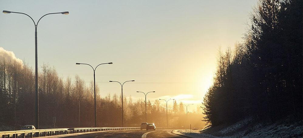 Sunny road and two cars passing by