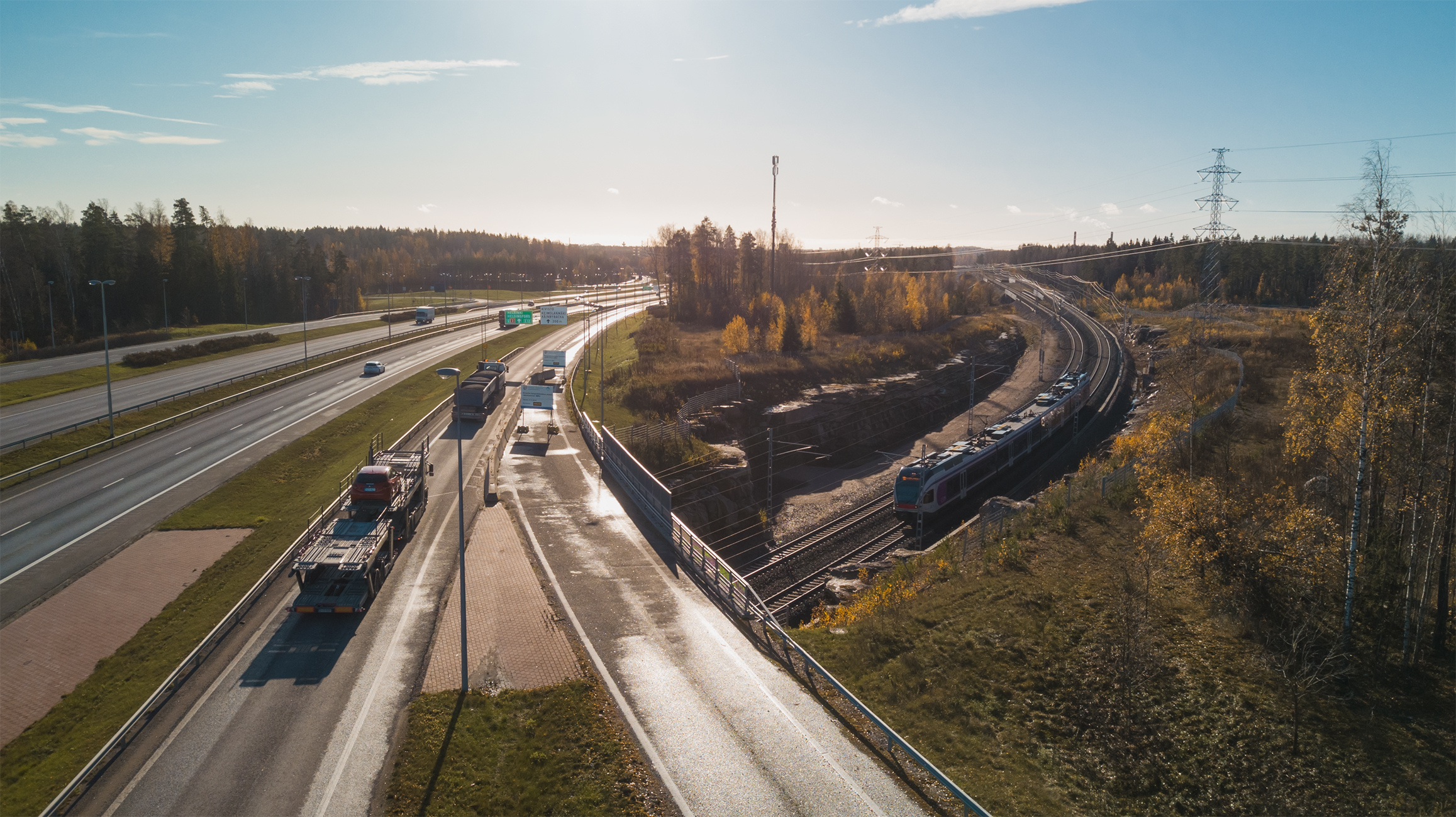 Moottoritie ja vieressä kulkeva rautatie kuvituskuvassa.