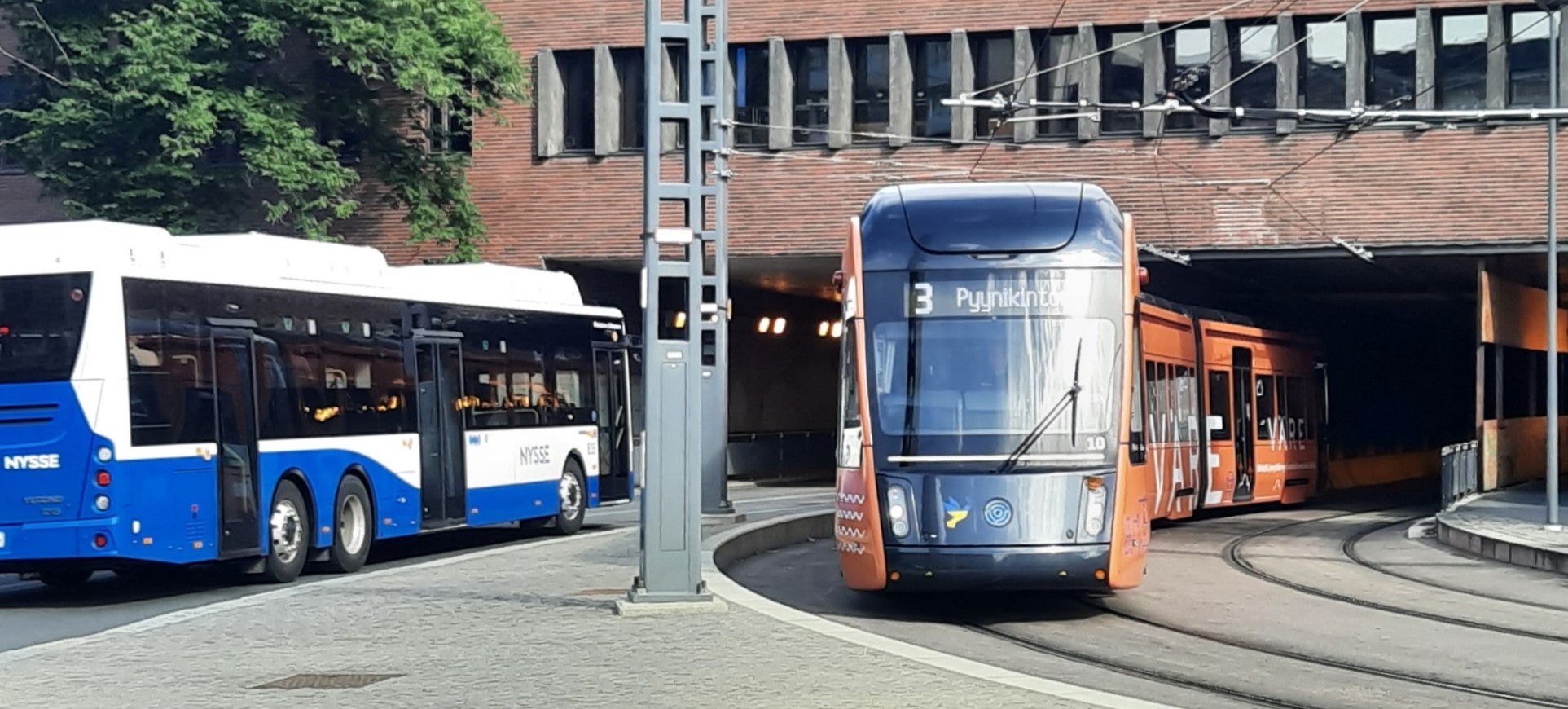 Itsenäisyydenkadun alikulkusilta kuvattuna lännestä kohti itää. Kuvassa linja-auto kulkee kohti itää ja Tampereen Ratikka kohti länttä. 