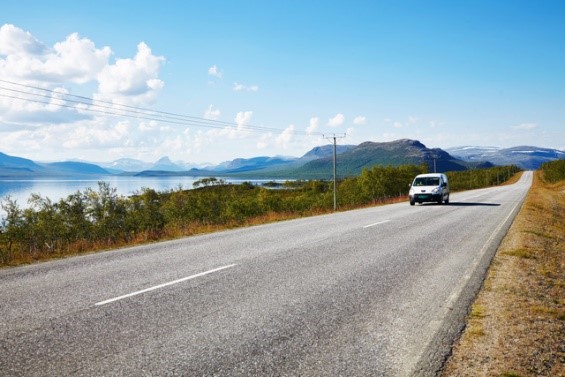 Bilen kör på en solig väg.