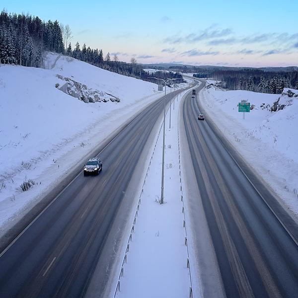 moottoritie, lumikinoksia, metsää, kalliota, autoja]