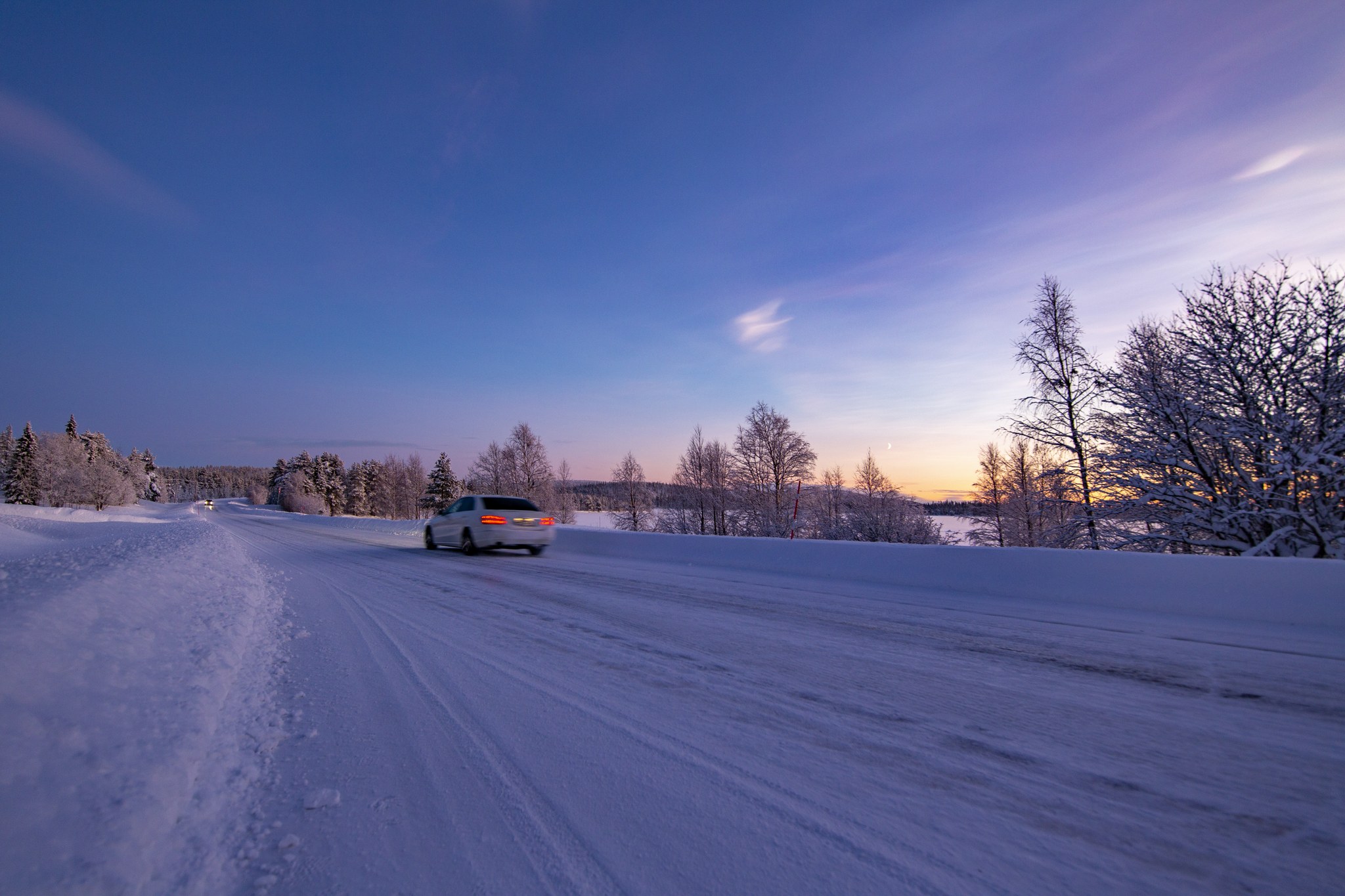 Kuva talvisesta tiestä Lapissa auringonlaskun aikaan.