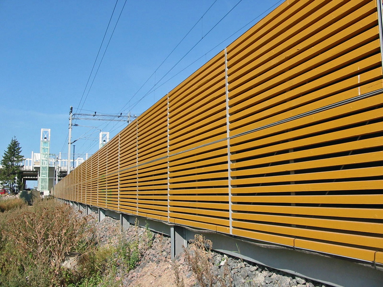 Kuvassa on esimerkki ratamelusuojasta, joka on sijoitettu junaradan läheisyyteen.