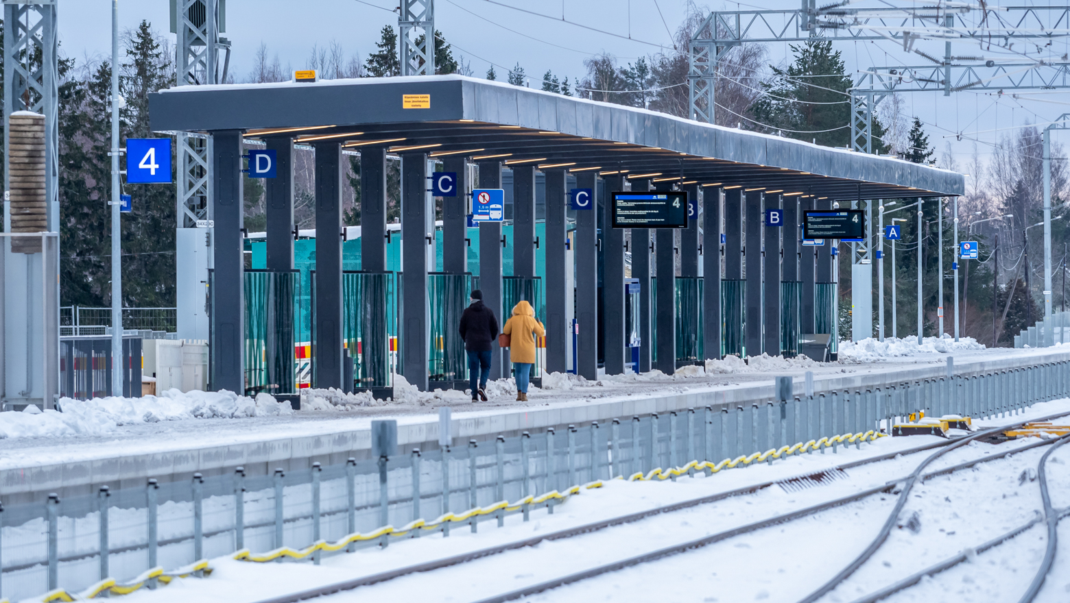 Kävelijöitä talvella Ainolan aseman uudella itäisellä laiturilla numero 4. 