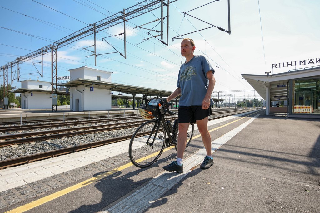 En man leder sin cykel på plattformen vid Riihimäki station