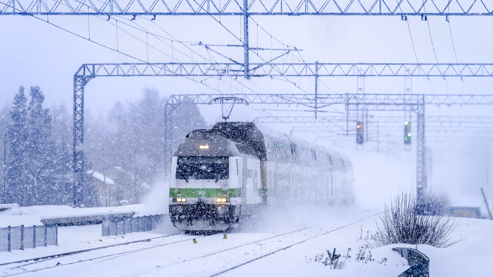 Juna ajaa lumituiskussa. 