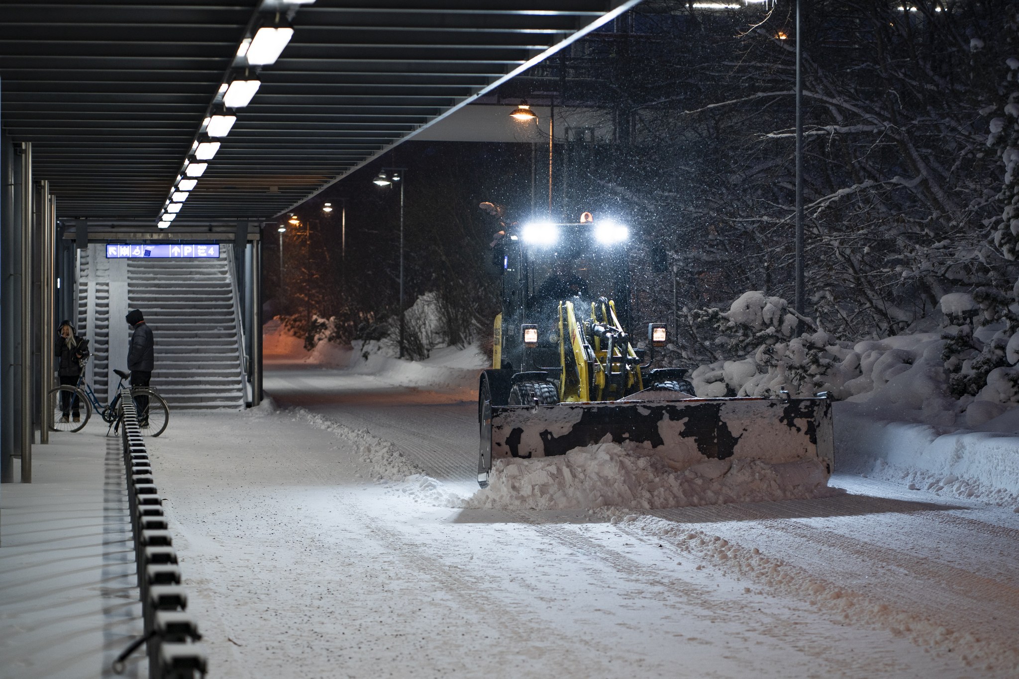 Rautatieaseman kävelytien aurausta talvella.