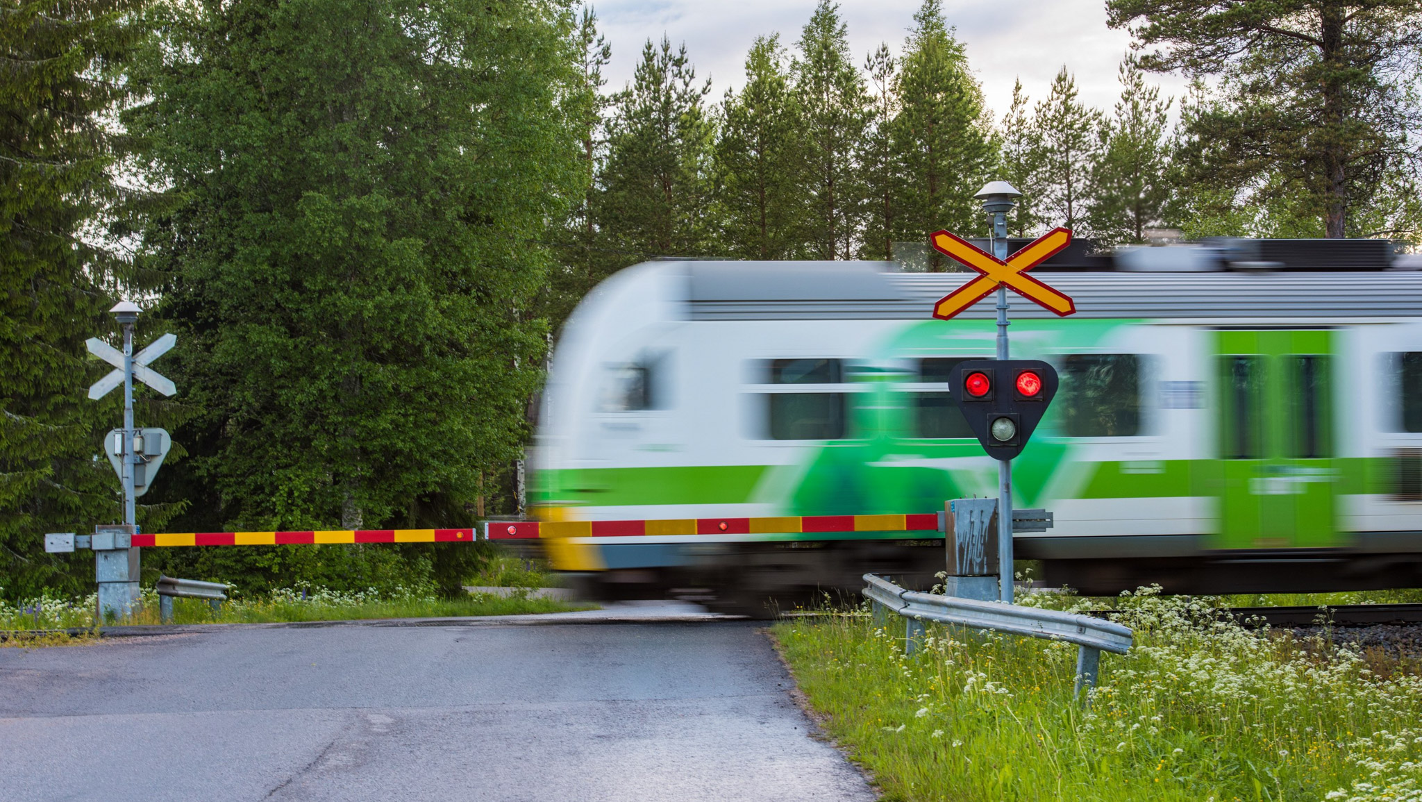 Juna ylittää tasoristeyksen vauhdilla