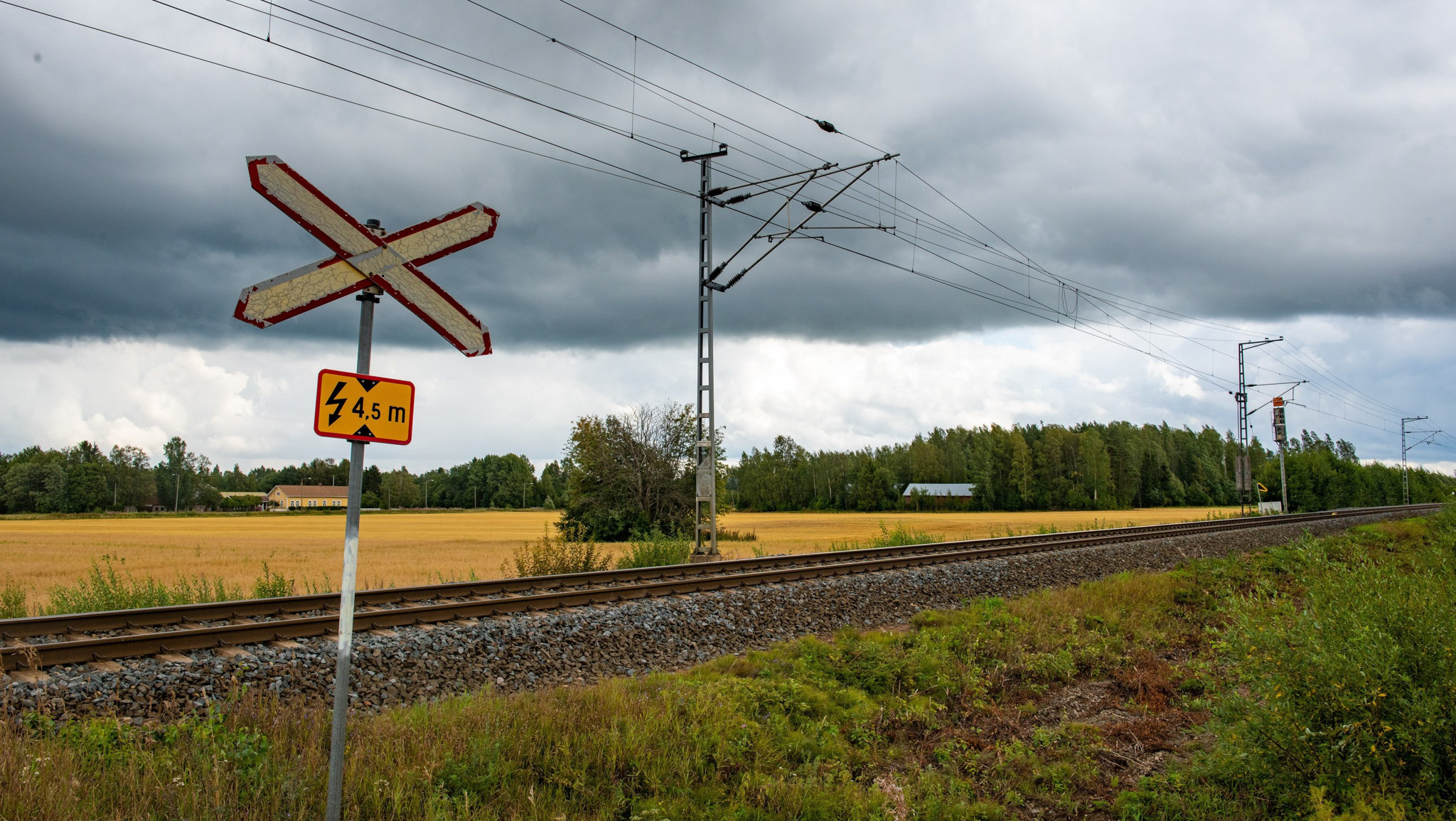 Tasoristeys kesäisessä maalaismaisemassa ukkosilman vallitessa.