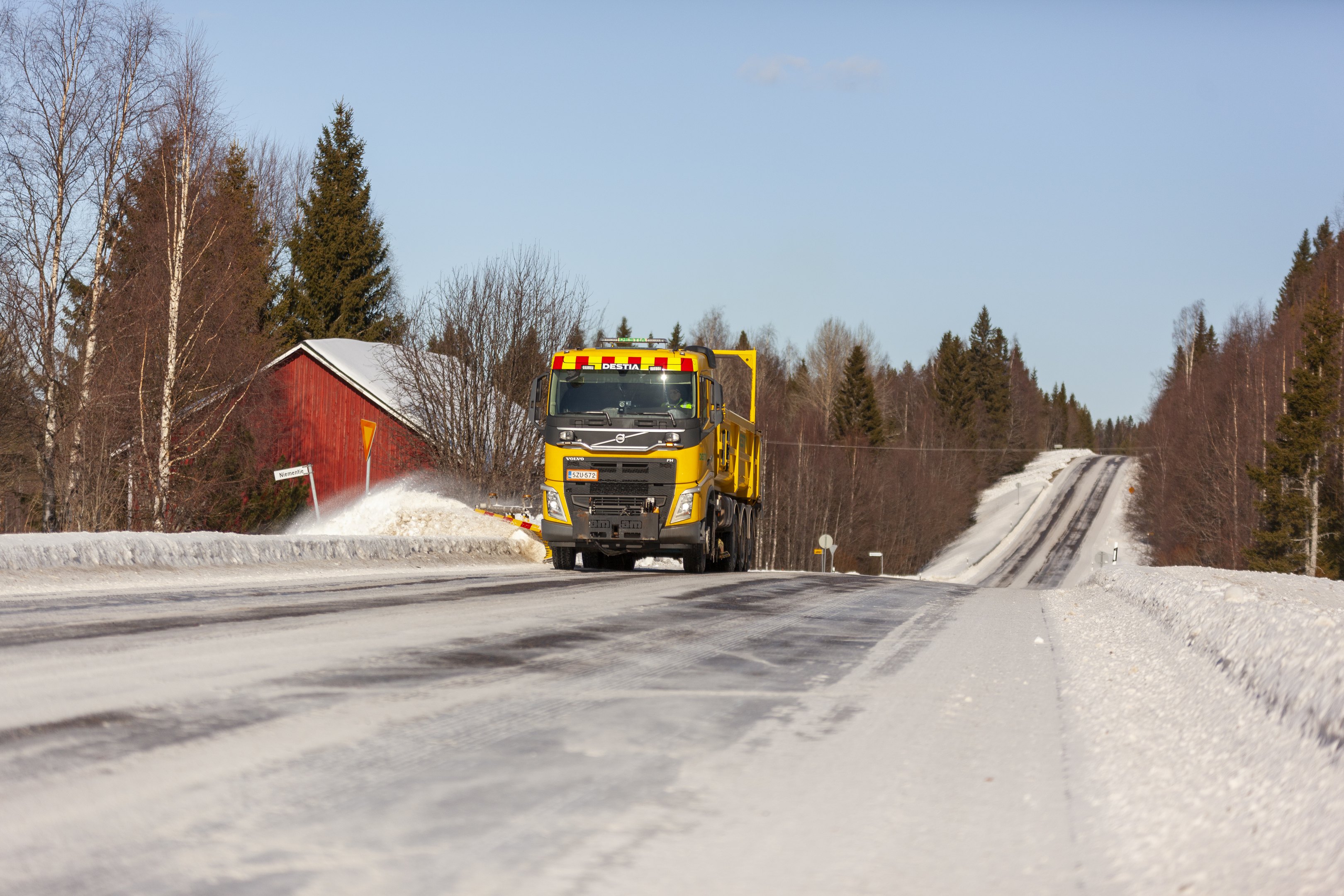 Lumivallien madallusta aurauskalustolla maantiellä.