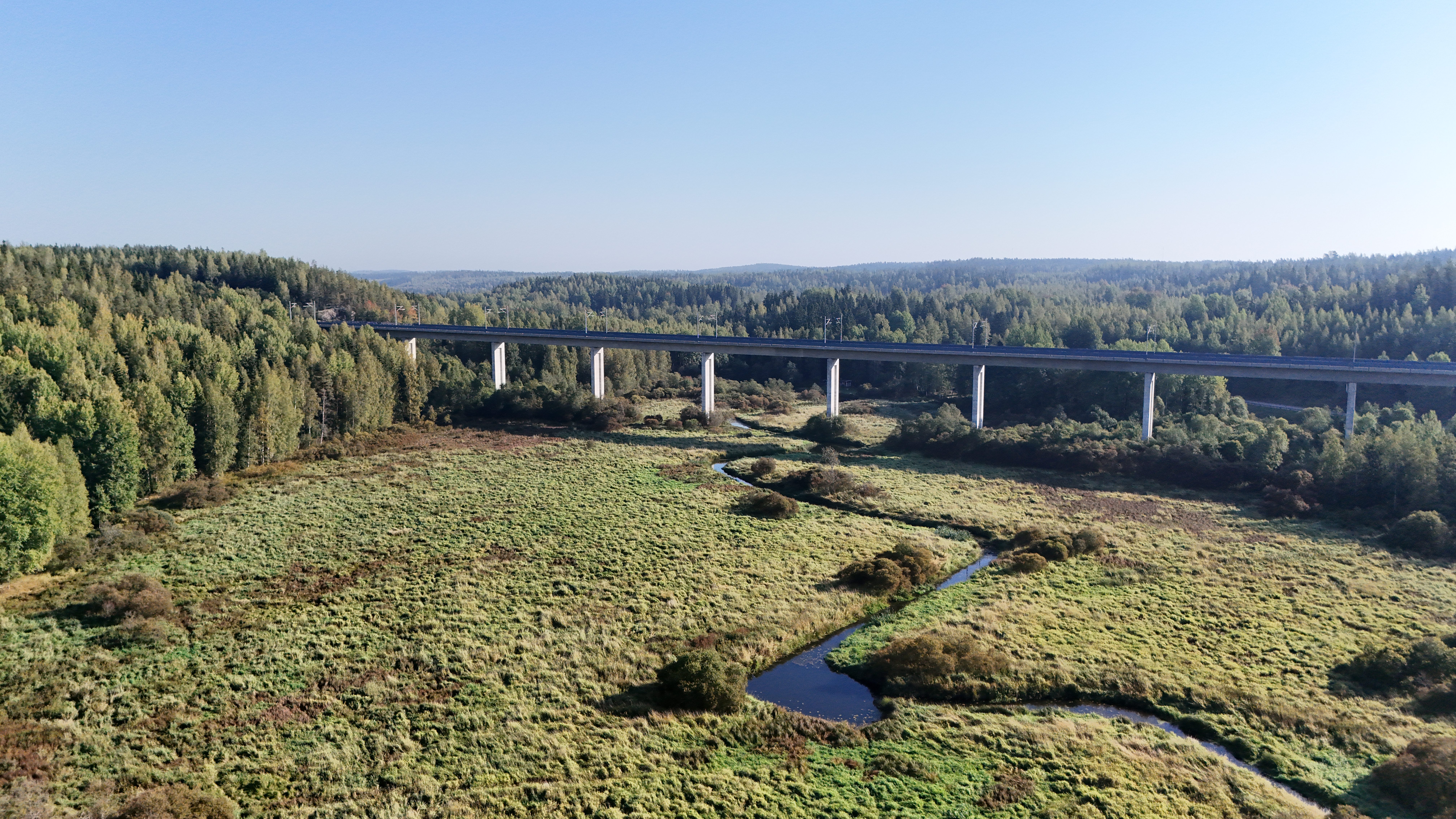 edessä vehreää, taustalla silta