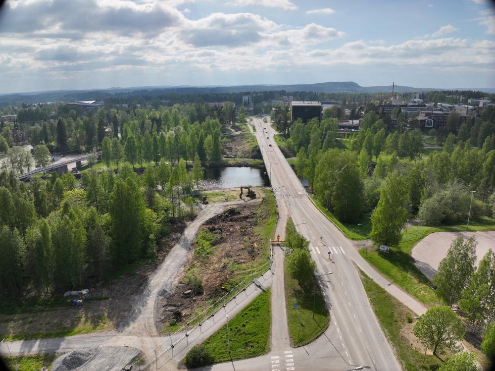Laaja ilmakuva Äänekosken siltahankealueesta. Kuvassa näkyvät nykyinen silta, työmaa-alue, raivattua maastoa sekä ympäröivä kaupunkimaisema ja järvi.
