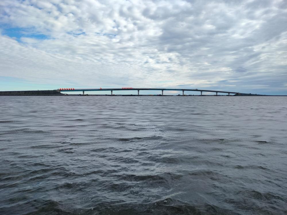 Pitkä silta, jonka päällä on katos, sillan etu- ja taka-alalla vettä.
