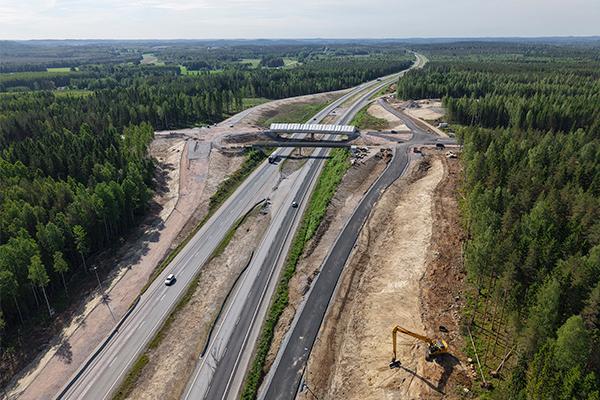 Ilmakuva valtatiestä 3 Hämeenlinnassa. Kuvan keskellä on Moreenin risteyssilta sekä Pullolan risteyssilta, jotka ylittävät moottoritien. Tien molemmilla puolilla näkyy rakenteilla olevaa eritasoliittymää ja tiheää metsää. Moottoritiellä kulkee yksittäisiä autoja.