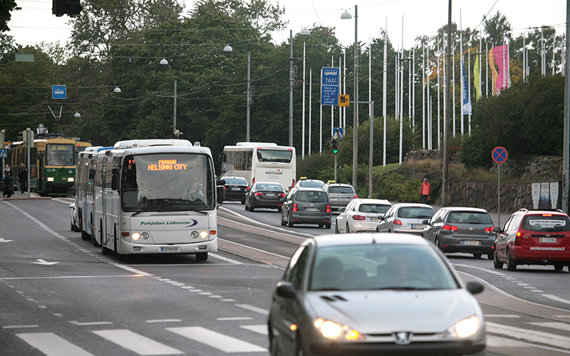 Kuvassa näkyy julkista liikennettä ja henkilöautoja Helsingin keskustassa.