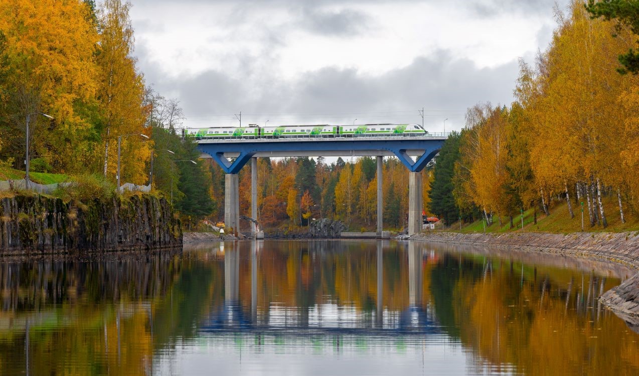 Henkilöjuna ylittää Saimaan kanavan uuden ratasillan syksyisessä maisemassa.