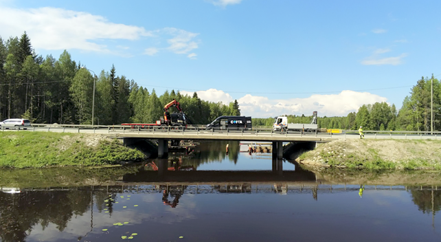 Autoja ja työkoneita korjattavalla sillalla aurinkoisena kesäpäivänä.