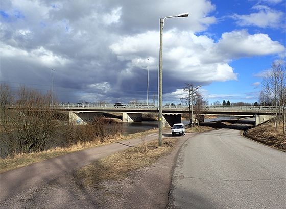 Valokuva, jossa taustalla silta, jonka alittaa maantie ja kevyen liikenteen väylä.