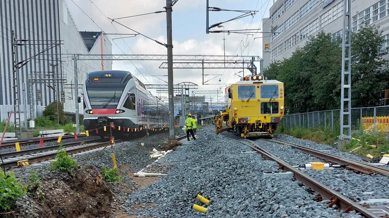 Paikallisjuna ja kiskotyökone rinnakkain Tikkurilan asemalla heinäkuussa 2023.