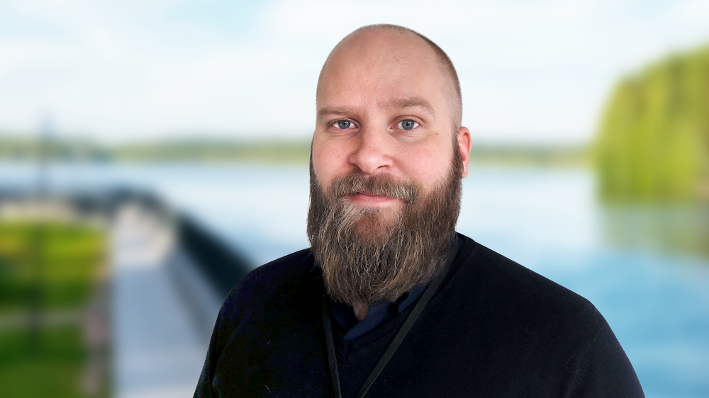 Kuvassa on parrakas mies. Hän katsoo suoraan kameraan.