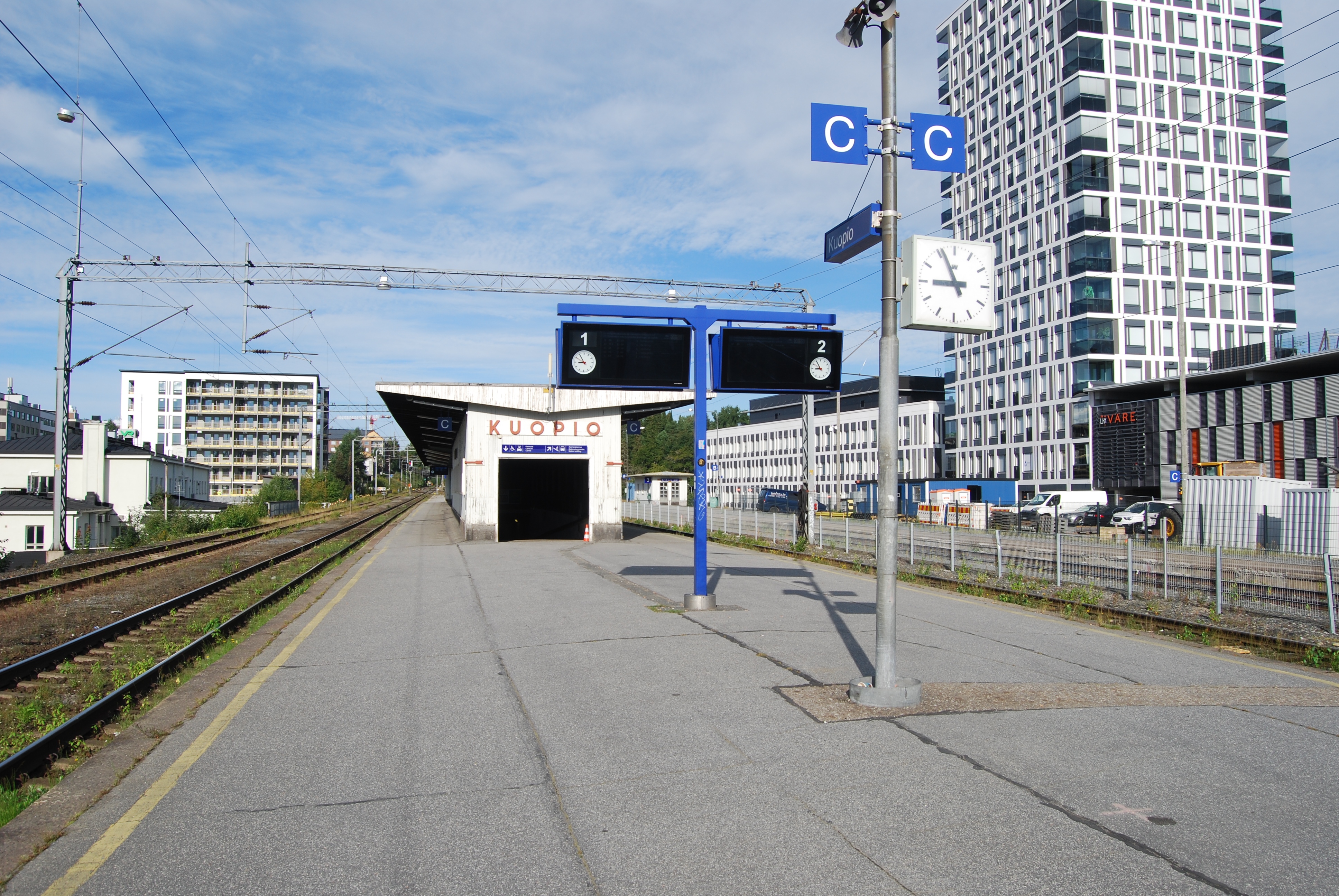 Kuopion ratapiha -hankkeen kuvituskuva, jossa on näkymä Kuopion juna-aseman katoksesta ja kyltistä, jossa lukee Kuopio