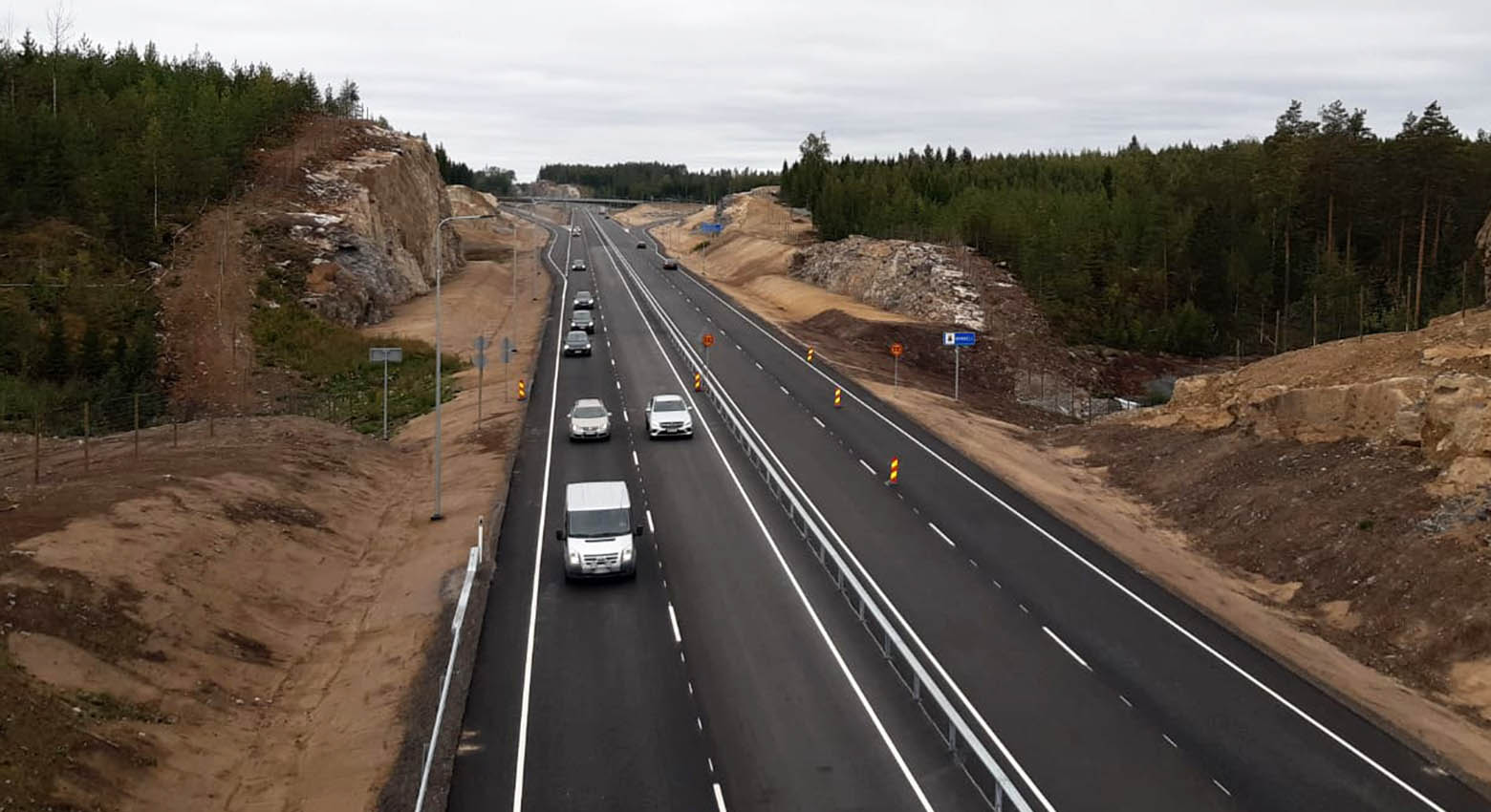 Autoja ajaa juuri valmistuneella asfalttitiellä.