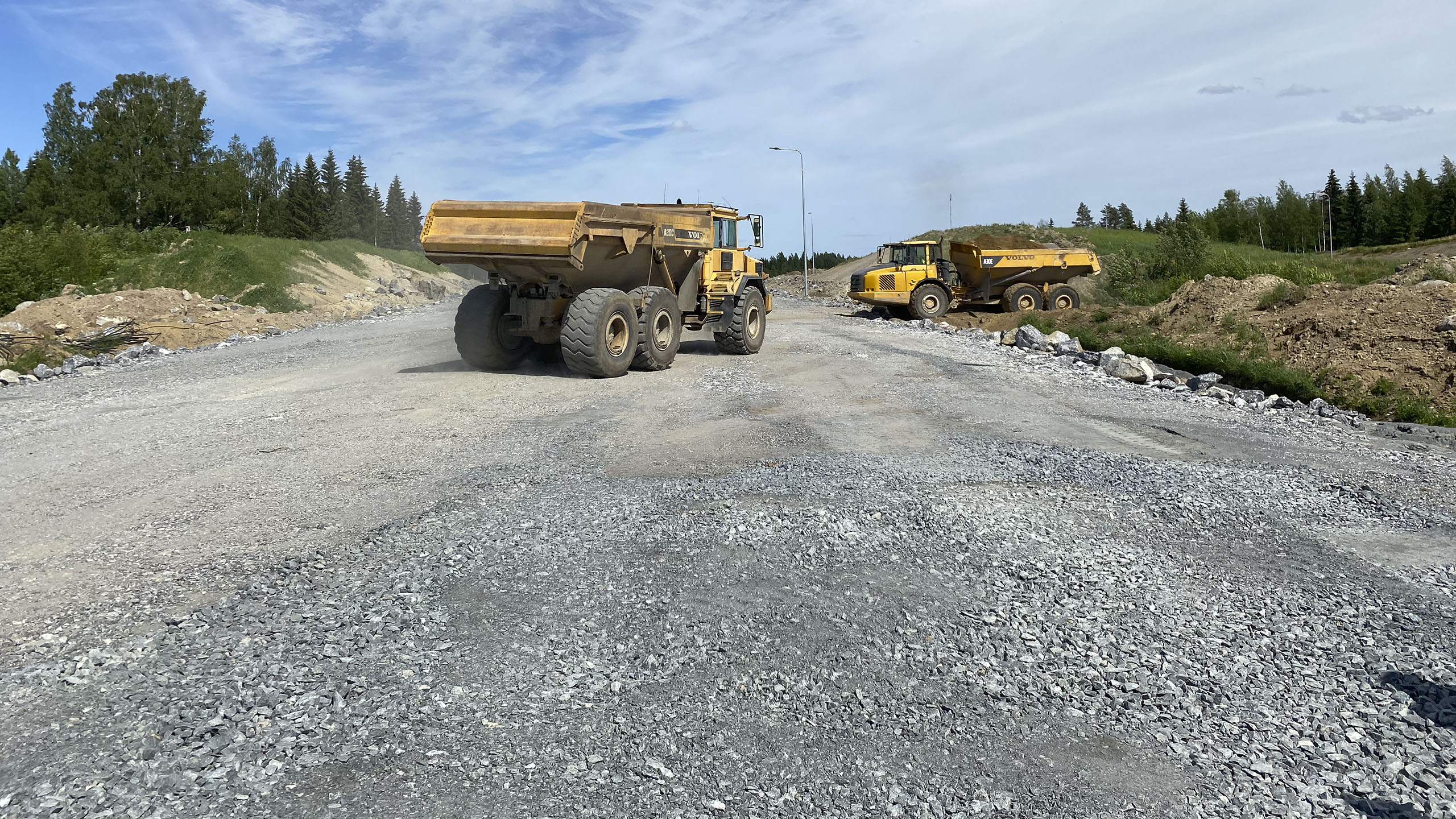 Näkymä Vt 5 Mikkeli-Juva työmaalle, kaksi keltaita dumpperia ajaa asfaltoimattomalla tien pohjalla.
