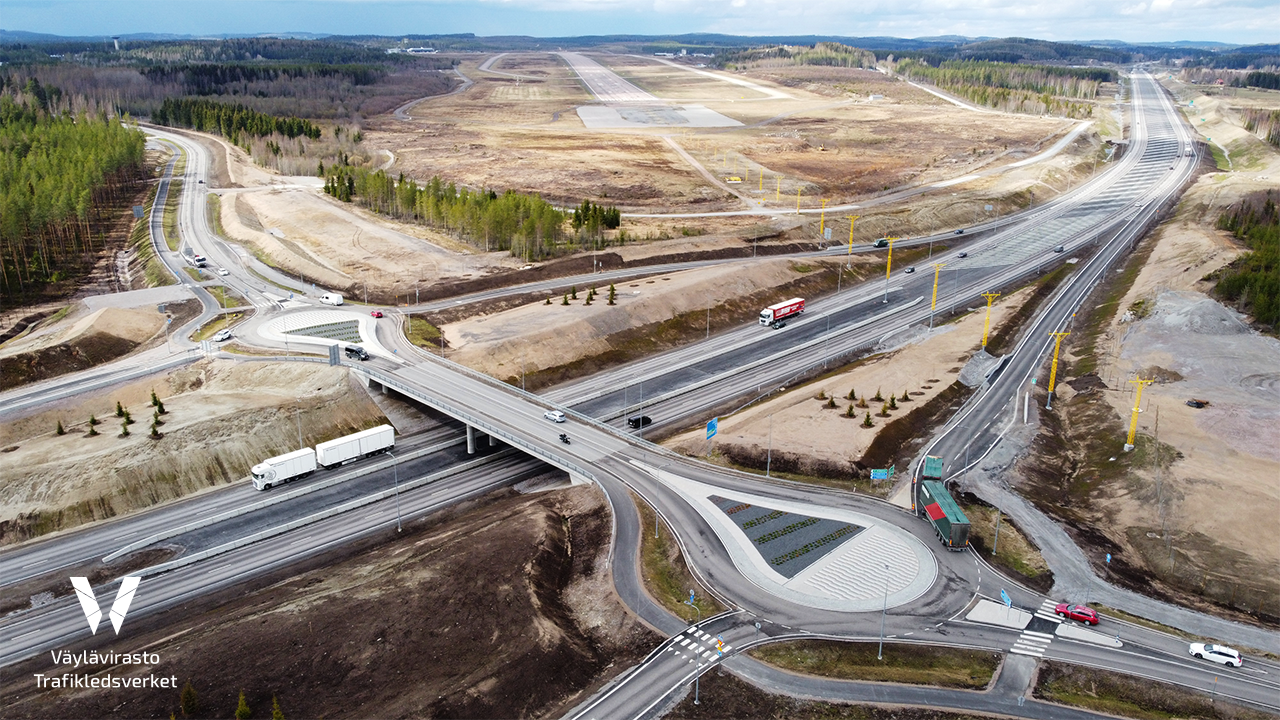 Neljäkaistainen moottoritie alittaa eritasoliittymän sillan. Sillalla kulkee ajoneuvoja.