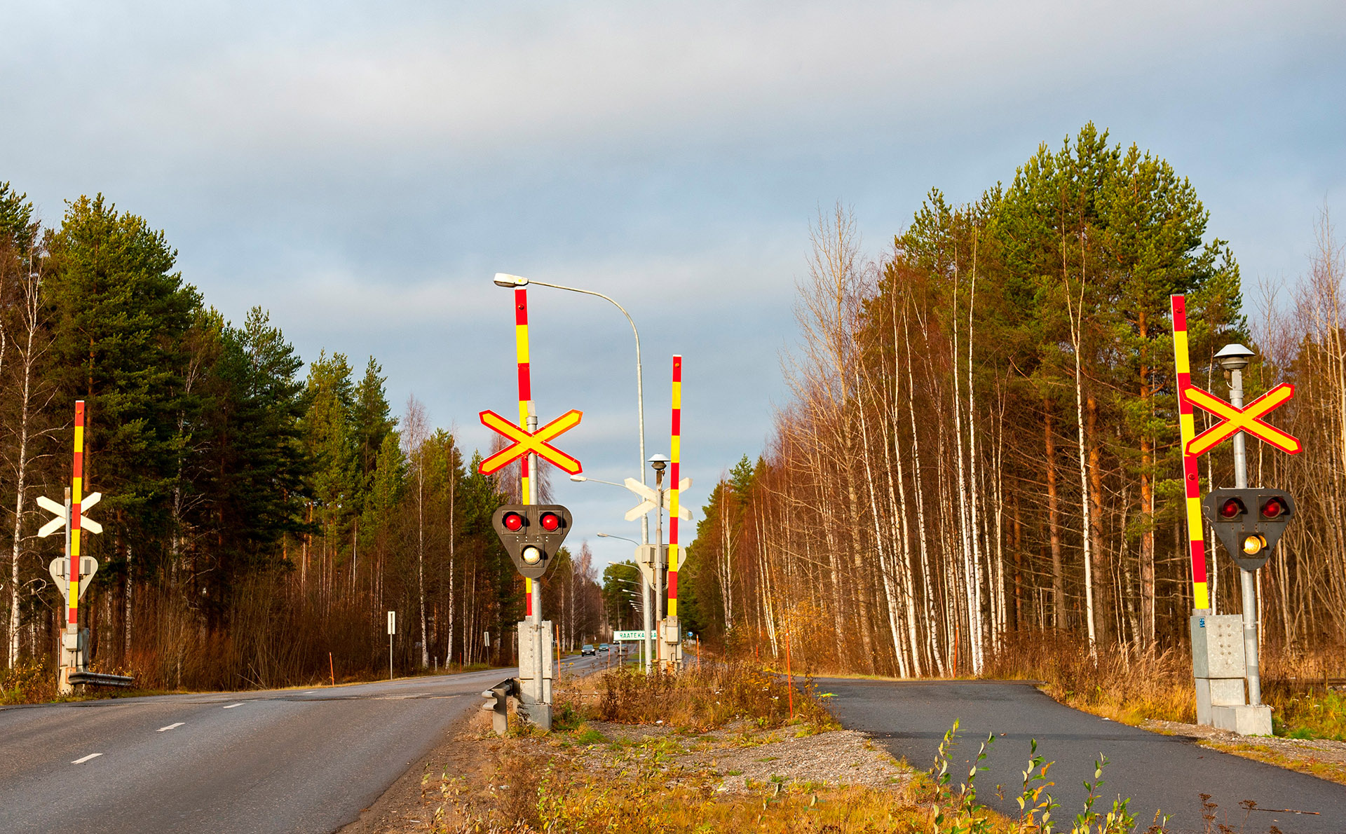 Tasoristeys puomeilla syksyllä. Tasoristeyksessä omat ylityspaikkansa autoille sekä kävelijöille/pyöräilijöille.