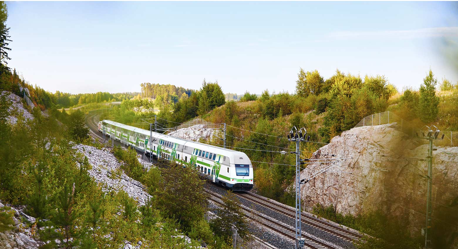Juna kulkee kallioisessa ja metsäisessä maisemassa.