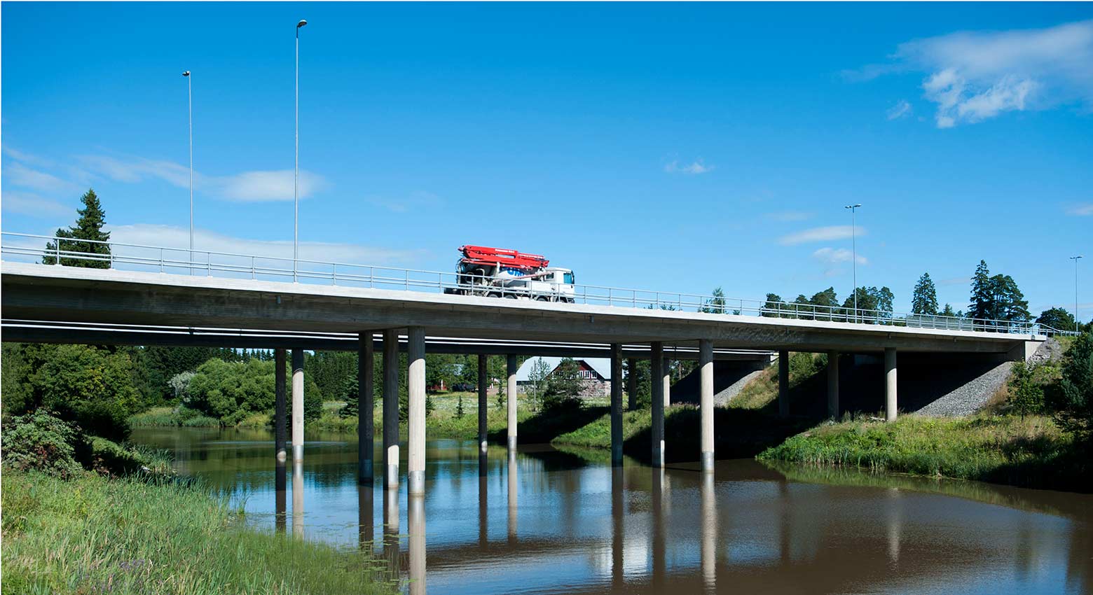 A summery road construction site with traffic passing by.