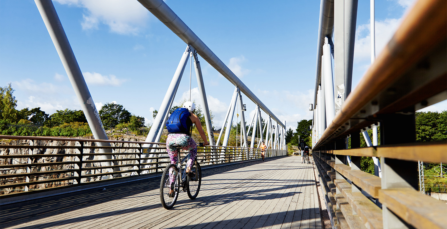 En människa cyklar över en bro