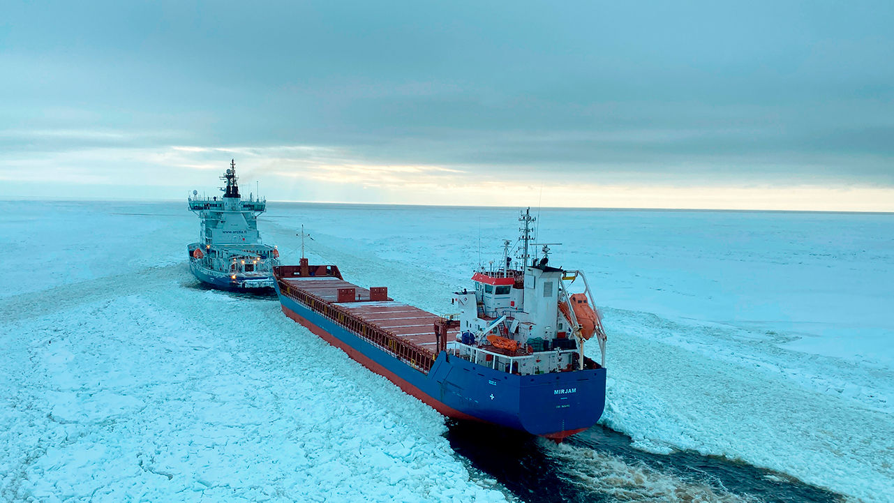icebreaker helping smaller vessel to move on icy waters of Bay of Bothnia