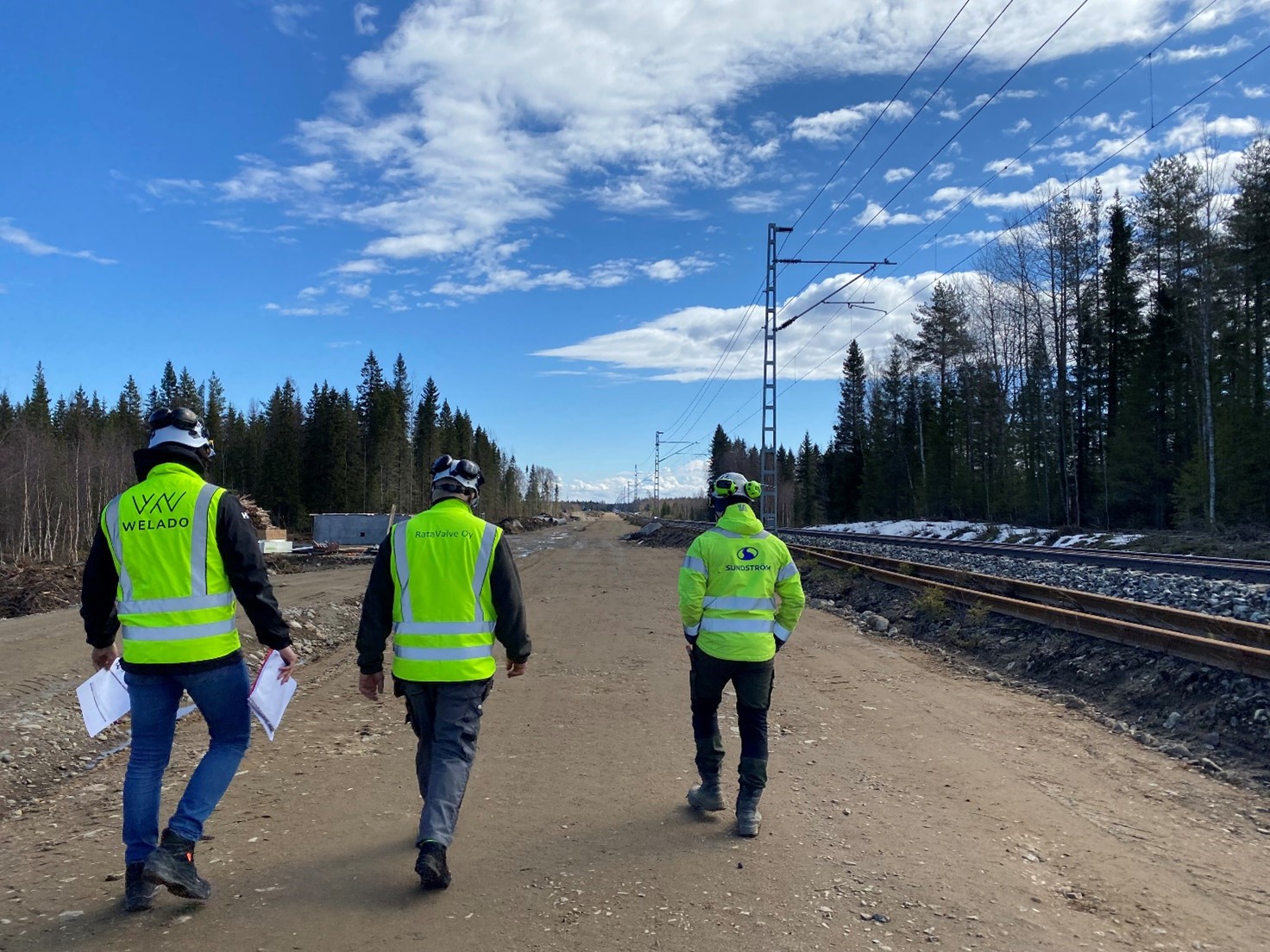 Työntekijät suorittamassa maa- ja vesirakennustyömaiden turvallisuusmittausta työmaalla.