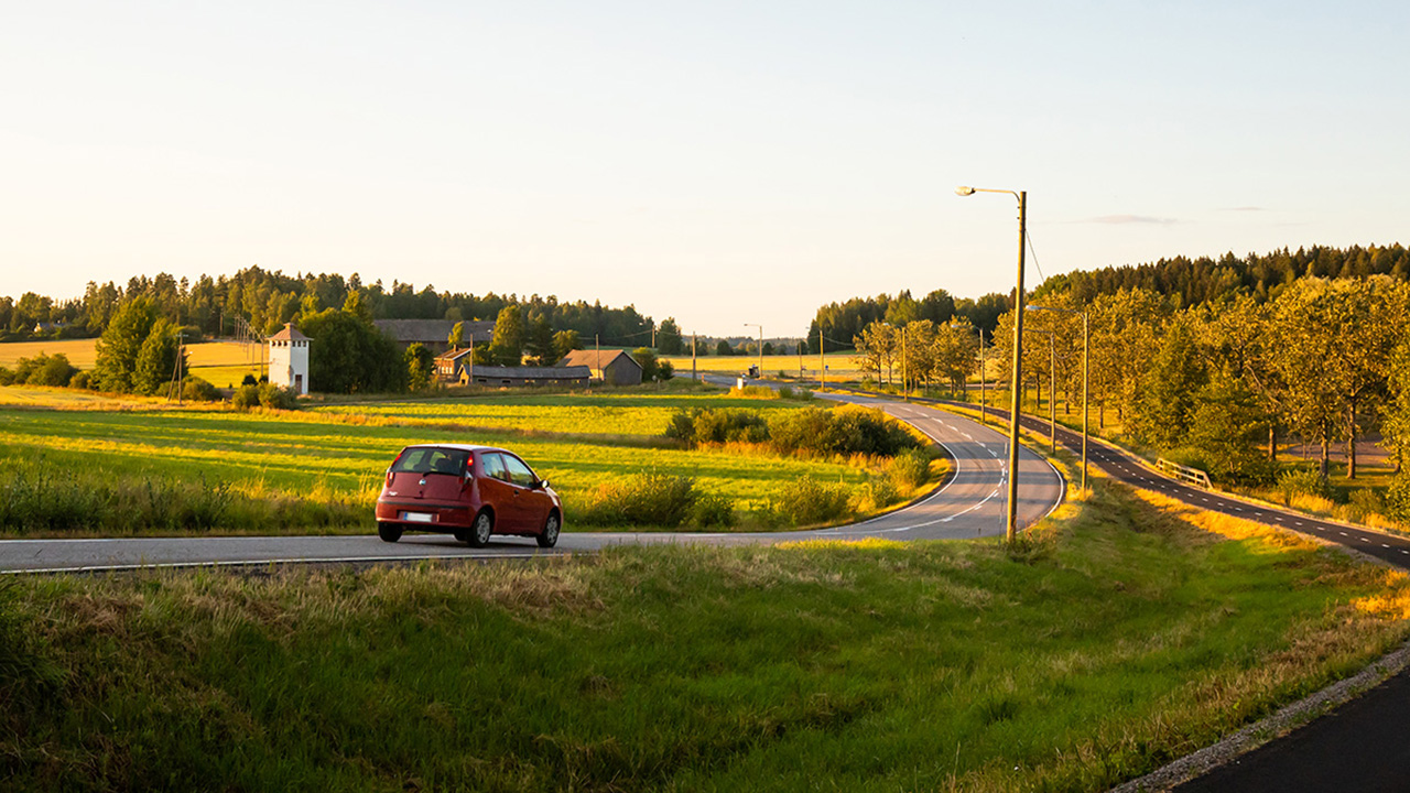 Kuvituskuva kesäisestä tiestä auringonlaskun aikaan.