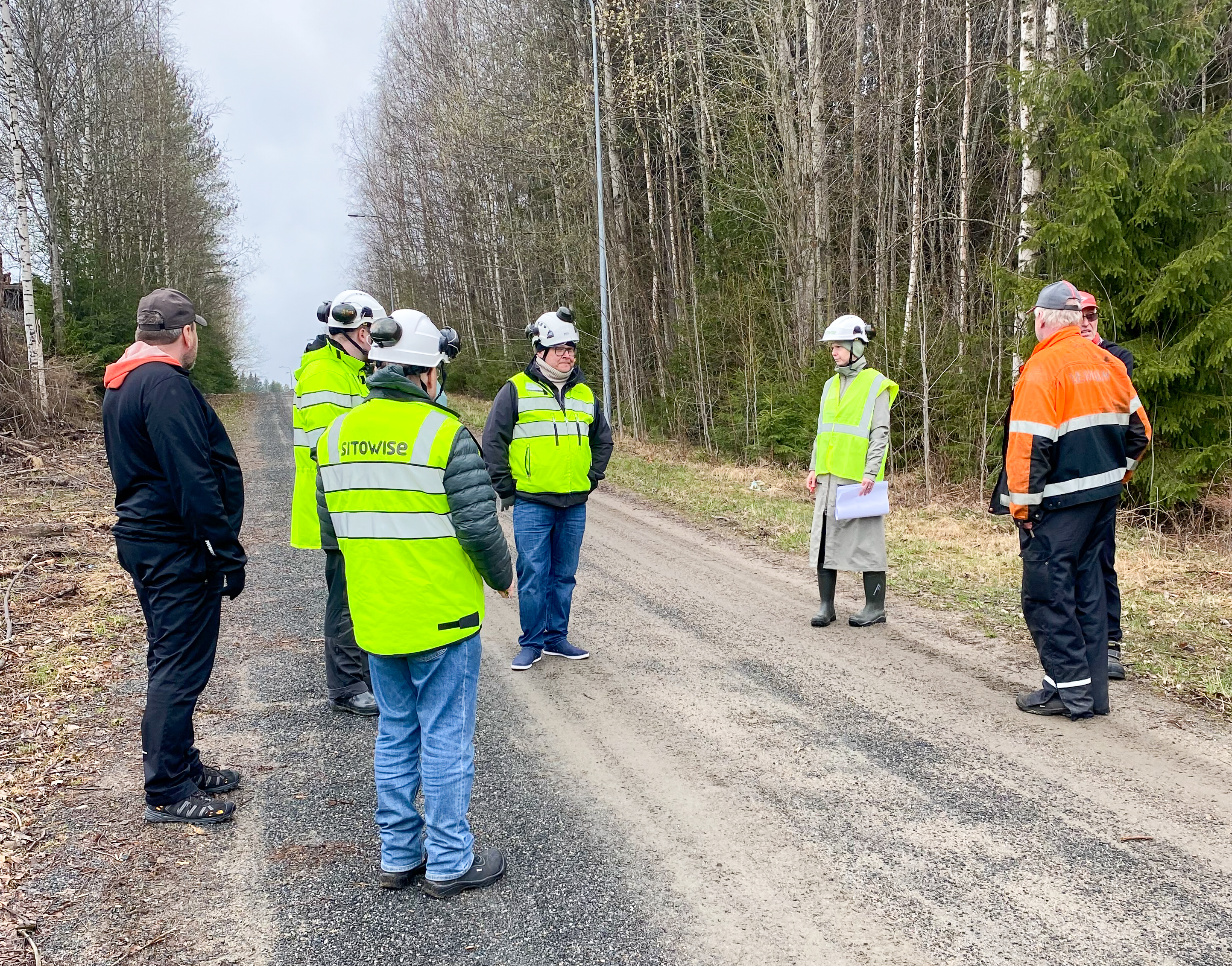 Kuvassa joukko ihmisiä maastossa keskustelemassa Lahdenperä-Jämsä-rataosan tasoristeysten poistokohteista.