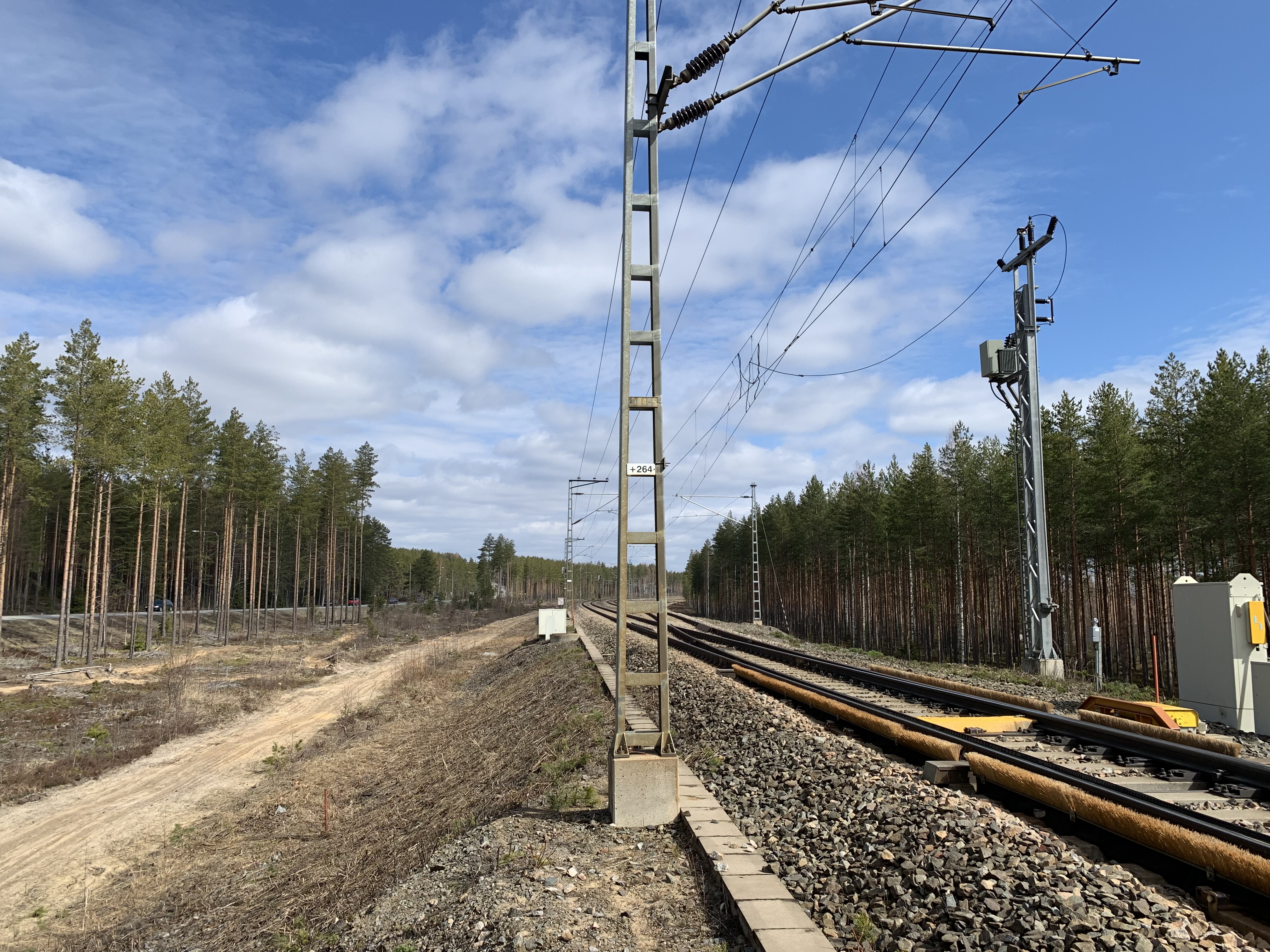 Kesäinen kuva Muuramen liikennepaikasta. Kuvassa näkyy rautatiekisko ja teknisiä laitteita.