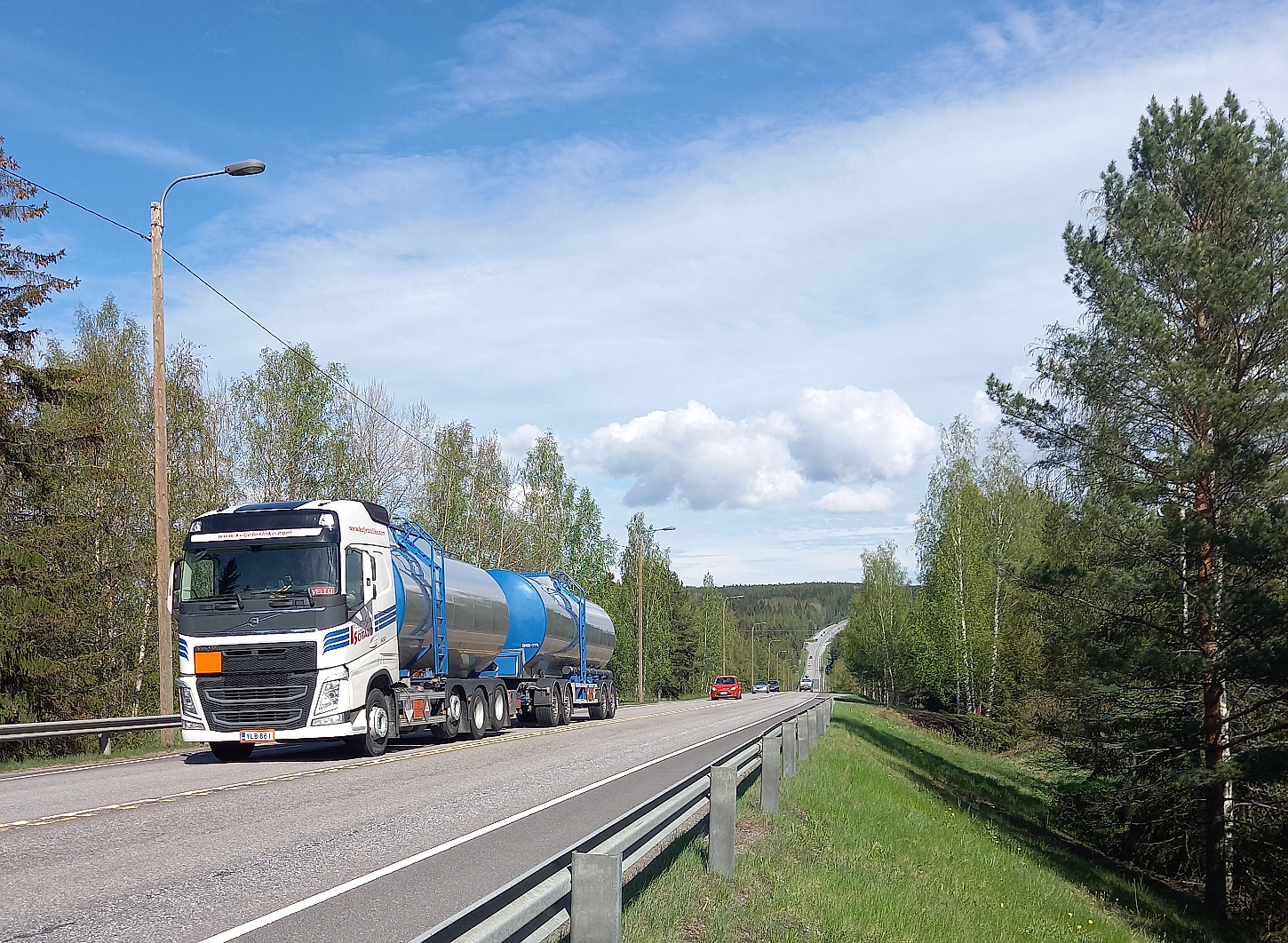 Raskas säiliöauto kiipeää jyrkkää Murhasaaren ahdetta ylöspäin. Perässä henkilöautoja, aurinko paistaa.