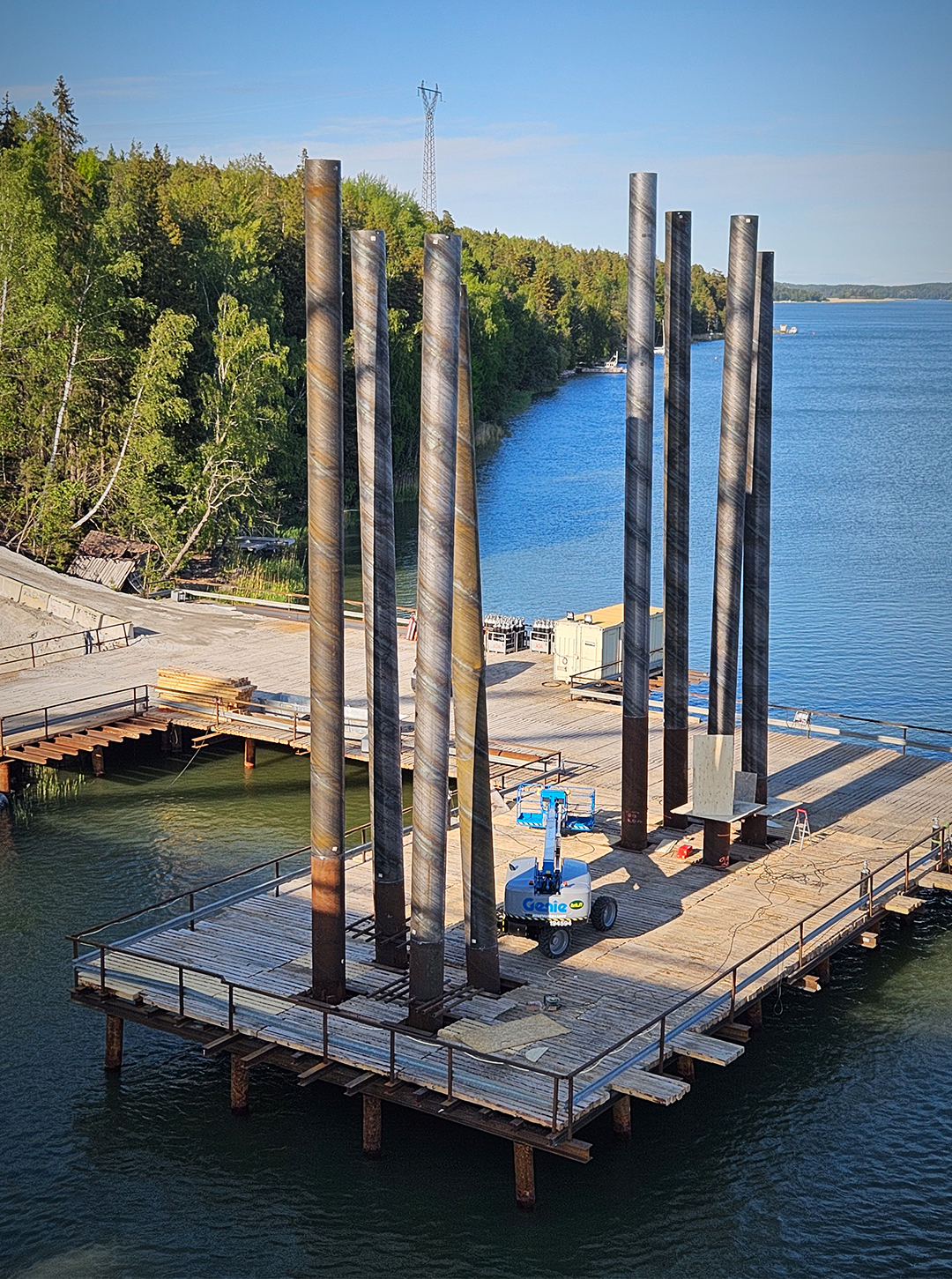 arbetsbro och pålar som reser sig från vattnet genom arbetsbron.