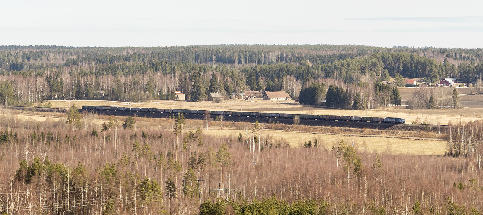 Tåget går mitt i det finska landsbygdslandskapet.