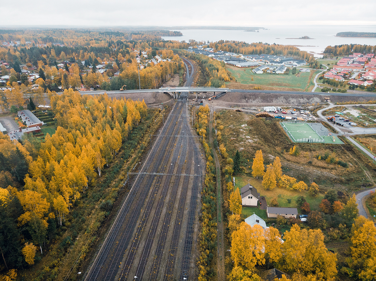 Flygfoto över tågstationen: en sjö och urban bosättning kan ses i bakgrunden.