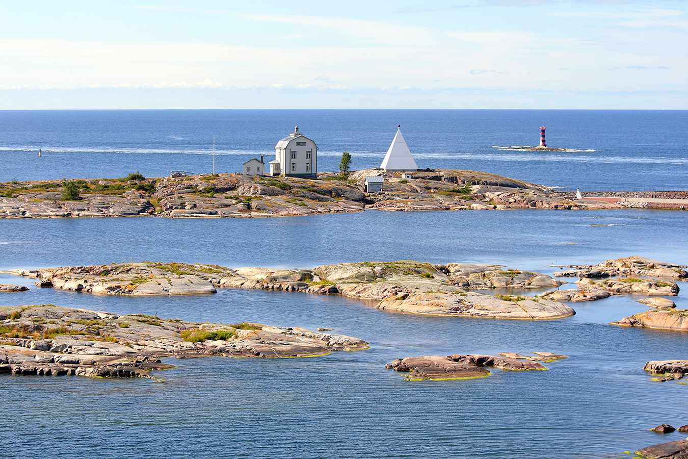 Finnish archipelago: an old wood house on a small island and a sea sign behind the house.