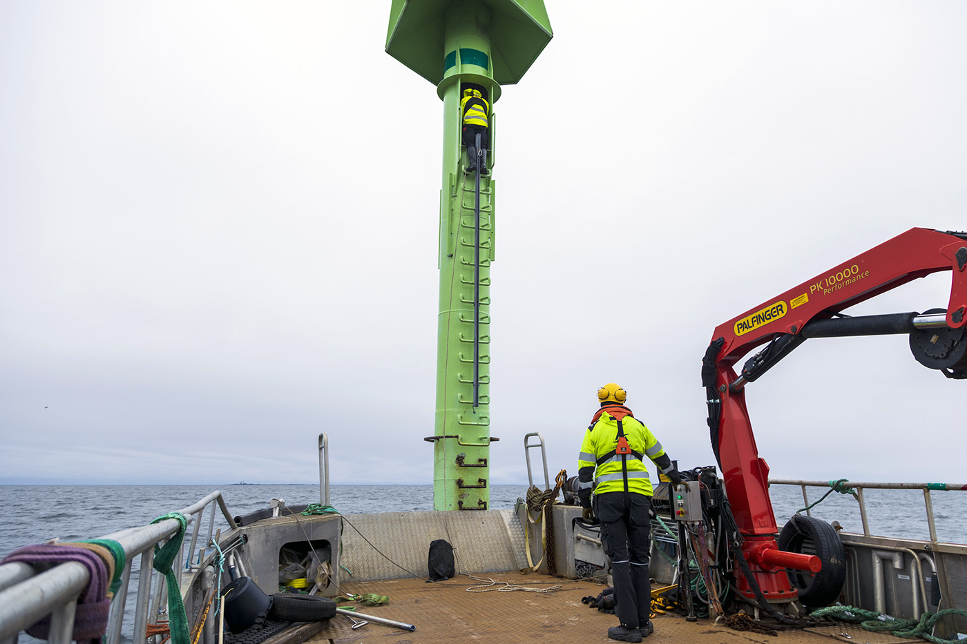 Workers taking care of a sea sign.